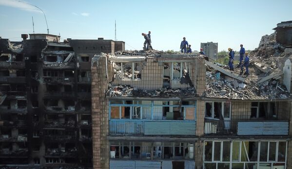 Сотрудники МЧС РФ разбирают завалы разрушенного дома на проспекте Мира в Мариуполе - Sputnik Молдова