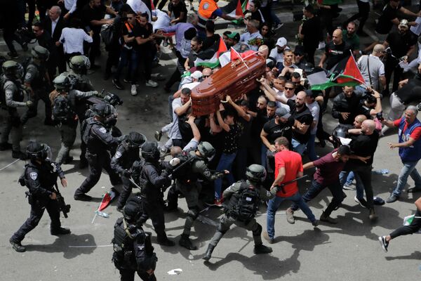 Столкновения израильской полиции с участниками траурной церемонии, которые несут гроб убитой журналистки-ветерана Аль-Джазиры Ширин Абу Акле во время ее похорон в восточном Иерусалиме, пятница, 13 мая 2022 года. Абу Акле, палестинско-американский репортер, более 25 лет освещавшая ближневосточный конфликт, была застрелена в среду во время израильского военного рейда в городе Дженин на Западном берегу. - Sputnik Молдова