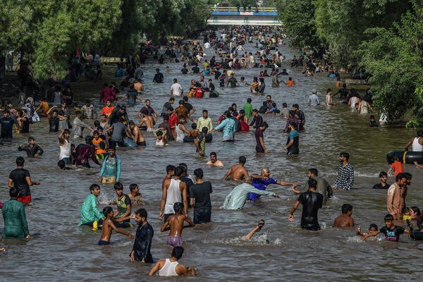 Люди охлаждаются в канале в жаркий летний день в Лахоре, 15 мая 2022 года. - Sputnik Молдова