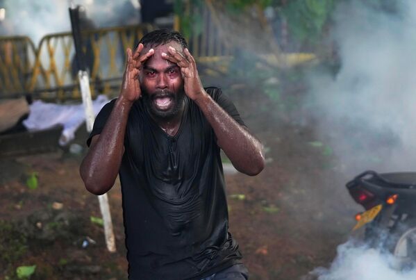 Раненый протестующий кричит от боли, когда полиция применяет слезоточивый газ для разгона протестующих членов Межуниверситетской федерации студентов во время антиправительственной акции протеста в Коломбо, Шри-Ланка, в четверг, 19 мая 2022 года. Жители Шри-Ланки протестуют уже более месяца, требуя отставки президента Готабая Раджапакса, возлагая на него ответственность за худший экономический кризис в стране за последнее время. - Sputnik Молдова