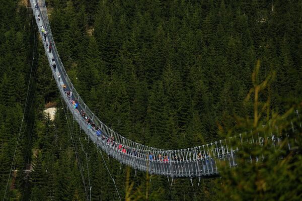 Посетители пересекают подвесной мост для пешеходов, который является самой длинной подобной конструкцией в мире, вскоре после его официального открытия на горном курорте в Долни Морава, Чешская Республика. Мост длиной 721 метр (2365 футов) построен на высоте более 1100 метров над уровнем моря. Он соединяет два хребта гор высотой до 95 метров над долиной между ними. - Sputnik Молдова