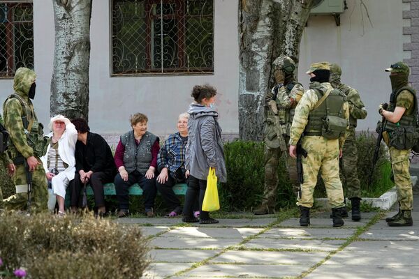 Un grup de pensionari vorbesc cu un grup de soldați ruși în regiunea Herson. Imaginea a fost surprinsă, vineri, 20 mai 2022. Această fotografie a fost făcută în timpul unei călătorii organizate de Ministerul rus al Apărării - Sputnik Moldova
