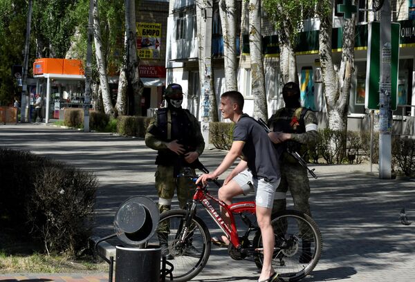Un biciclist trece pe lângă soldații ruși din regiunea Herson. Imaginea a fost surprinsă, vineri, 20 mai 2022 - Sputnik Moldova