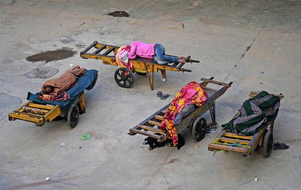 Носильщики спят на своих ручных тележках на вокзале в Нью-Дели, Индия. - Sputnik Молдова