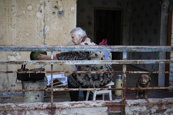 Женщина готовит еду на балконе жилого дома в Мариуполе - Sputnik Молдова