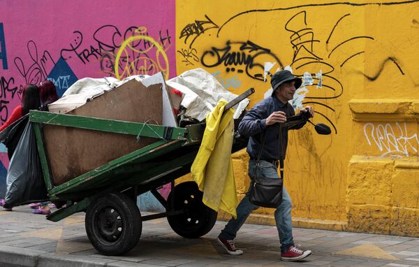 Jesus Maria Perez, în vârstă de 52 de ani, se plimbă pe străzile din Bogota adunând materiale reciclabile pentru a le vinde într-un depozit pentru o sumă modestă de bani, pe 25 mai 2022. - Sputnik Moldova
