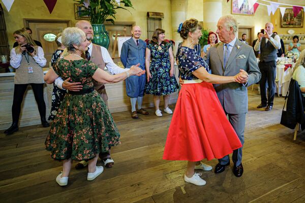 Принц Чарльз танцует с Бриджит Тиббс, фермером, занимающимся разведением альпак, на чаепитии, организованном Фондом принца в Глостершире в честь платинового юбилея царствования Елизаветы II. - Sputnik Молдова