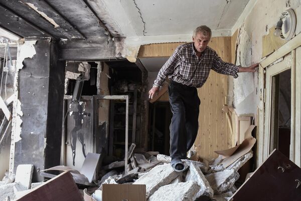 Мужчина в квартире разрушенного дома на одной из улиц в Мариуполе - Sputnik Молдова