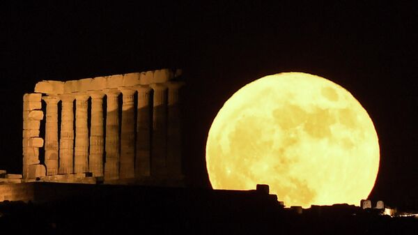 În imagine a fost surprinsă super luna sau Luna Căpșună în spatele Templului lui Poseidon, Sounion, Grecia. - Sputnik Moldova