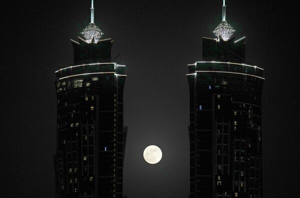 Super luna sau Luna Căpșună apare între două temple din orașul Dubai, Emiratele Arabe Unite. - Sputnik Moldova