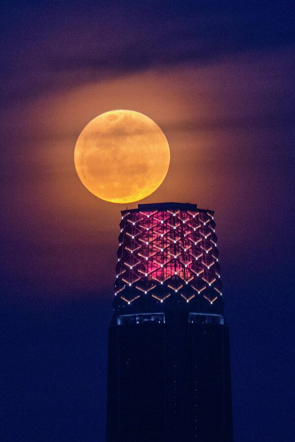 În imagine a fost surprinsă super luna sau Luna Căpșună în spatele The Exchange 106, cunoscut și sub numele de Turnul TRX din Kuala Lumpur, Malaezia. - Sputnik Moldova