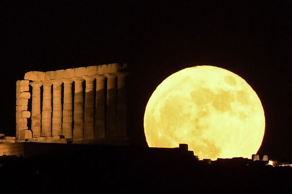 Полная луна, известная как &quot;Клубничная луна&quot;, за храмом Посейдона на мысе Сунион, к югу от Афин, 14 июня 2022 года. - Sputnik Молдова