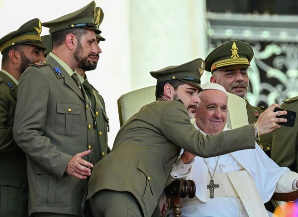 Папа Франциск позирует для селфи с офицерами итальянской армии во время еженедельной общей аудиенции 15 июня 2022 года на площади Святого Петра в Ватикане. - Sputnik Молдова