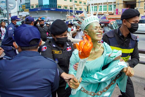 Камбоджийско-американская правозащитница Теари Сенг, одетая как Леди Либерти, арестована полицией после того, как 14 июня 2022 года в муниципальном суде Пномпеня ее признали виновной в государственной измене. - Sputnik Молдова