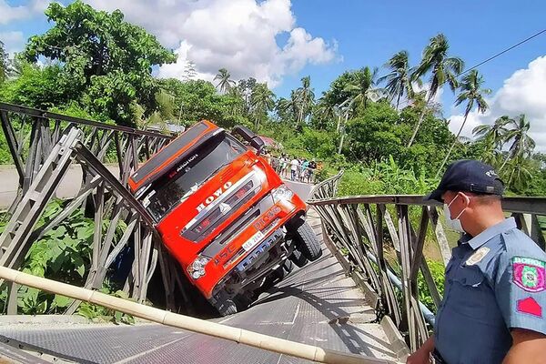 Перегруженная фура завалилась набок после обрушения моста, когда автомобиль пересекал Катигбиан в центральной филиппинской провинции Бохоль. - Sputnik Молдова