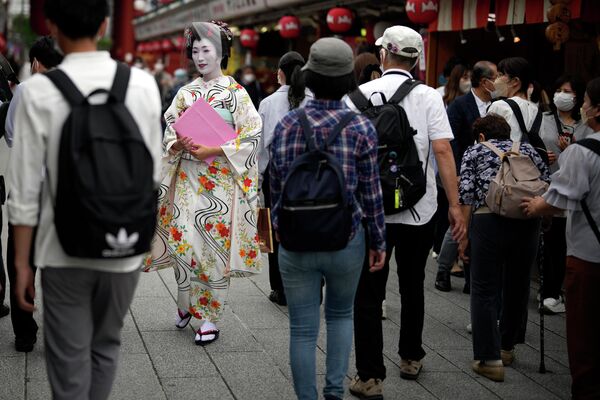Женщина-гейша в традиционном японском кимоно идет по торговой улице в районе Асакуса в пятницу, 10 июня 2022 года, в Токио.  - Sputnik Молдова
