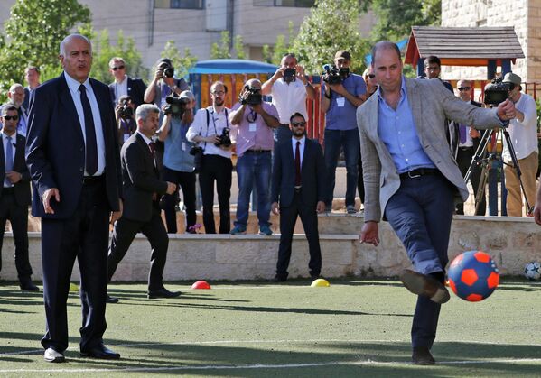 Prințul William al Marii Britanii lovește mingea, alături de șeful Federației Palestiniene de Fotbal, Jibril Rajoub (stânga), în orașul Ramallah din Cisiordania, pe 27 iunie 2018. - Ducele de Cambridge este primul membru al familiei regale care a efectuat o vizită oficială în statul evreu și teritoriile palestiniene. - Sputnik Moldova