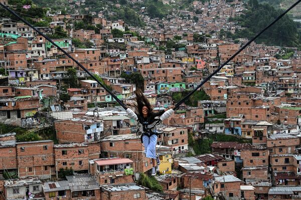 Туристка катается на аттракционе в районе Ла-Комуна 13 в Медельине, Колумбия. - Sputnik Молдова