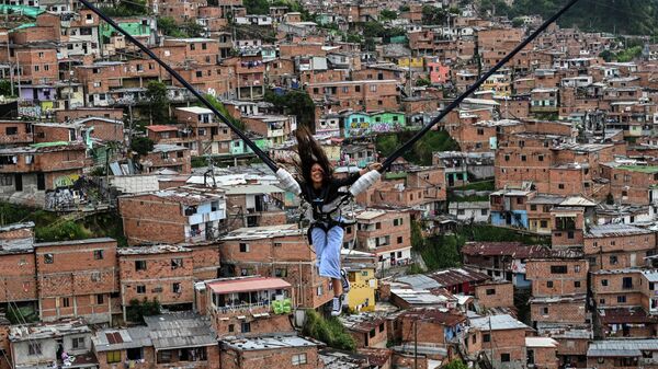 Турист катается на аттракционе в районе Ла-Комуна 13 в Медельине, Колумбия - Sputnik Молдова