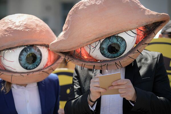 Активисты в масках принимают участие в акции протеста в Бухаресте против закона, расширяющего полномочия разведслужбы Румынии. - Sputnik Молдова