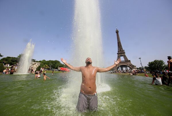 Мужчина пытается охладиться в фонтанах Трокадеро напротив Эйфелевой башни в Париже. - Sputnik Молдова