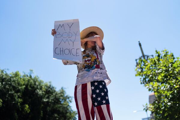 Активистка Элеанор Уэллс вытирает лицо с плакатом &quot;Мое тело – мой выбор&quot; на демонстрации в Лос-Анджелесе. - Sputnik Молдова