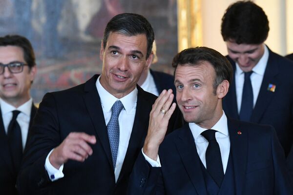 Prim-ministrul Spaniei Pedro Sanchez și președintele francez Emmanuel Macron vorbesc după ce au pozat într-o fotografie de familie la Summit-ului NATO din Madrid - Sputnik Moldova-România