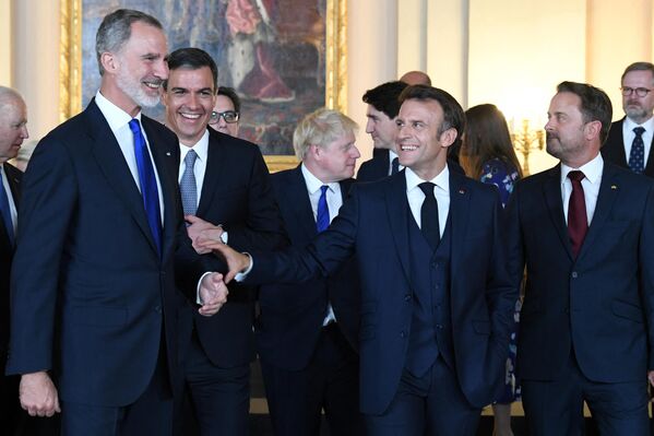 Prim-ministrul Spaniei, Pedro Sanchez (al doilea din stânga), Regele Spaniei Felipe VI (stânga) și președintele Franței Emmanuel Macron discută după fotografia de grup realizată înainte de cina găzduită de cuplul regal spaniol cu ​​cei invitați la programul oficial al summit-ului NATO de la Palatul Regal din Madrid, la 28 iunie 2022. - Sputnik Moldova