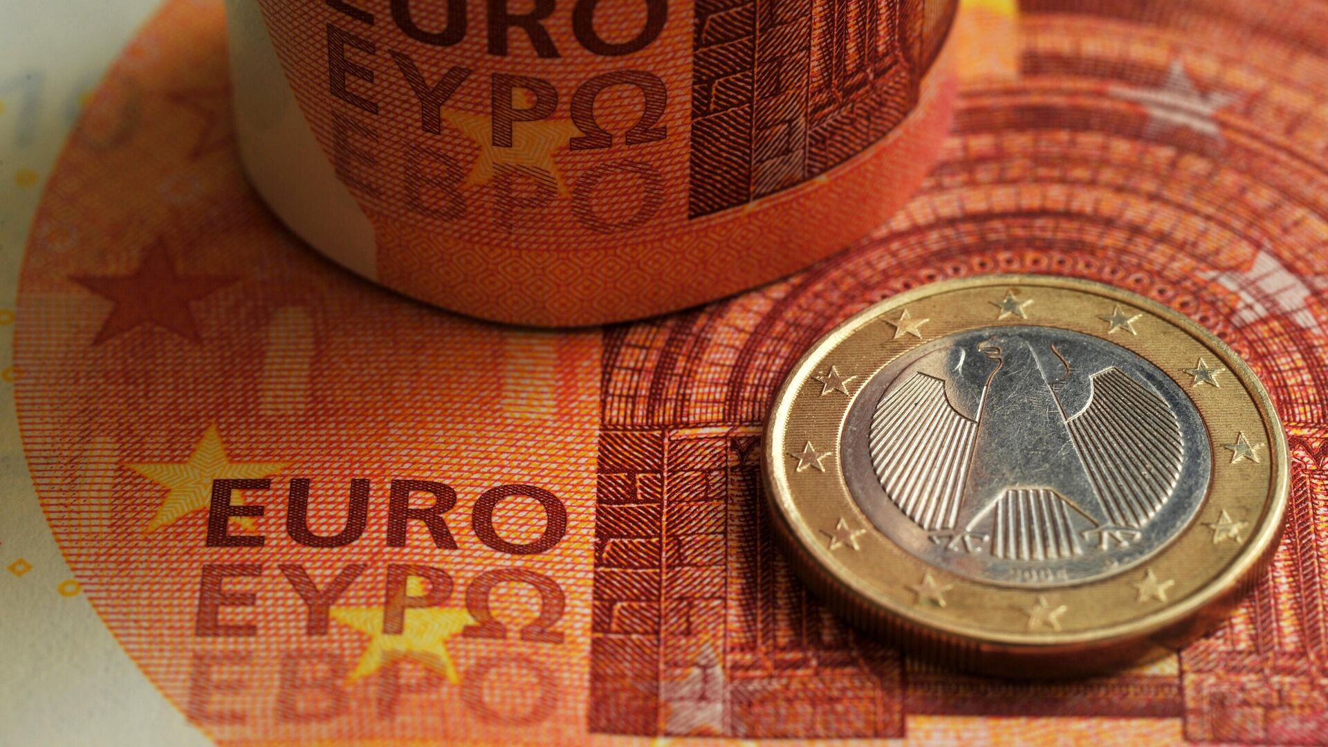 Монета номиналом 1 евро на фоне фрагмента банкноты номиналом 10 евро.  - Sputnik Молдова, 1920, 09.08.2023
