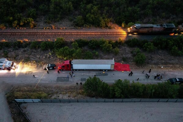 Сотрудники правоохранительных органов осматривают грузовик в Сан-Антонио, США, в котором были найдены погибшими 46 человек, предположительно, мигранты из Мексики. Еще около 10 выживших, пострадавших от теплового удара, были доставлены в местные больницы. - Sputnik Молдова
