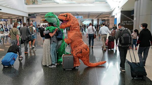 Встреча в аэропорту: люди, одетые в костюмы динозавров, приветствуют своего друга в Солт-Лейк-Сити - Sputnik Молдова