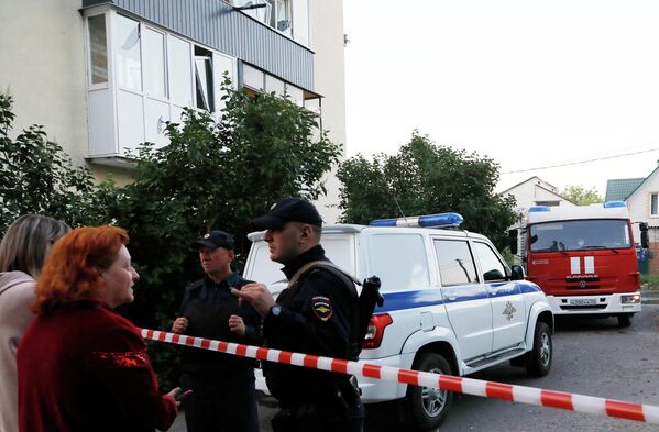 Localnici și polițiști în apropierea unei clădiri rezidențiale avariate din Belgorod. - Sputnik Moldova
