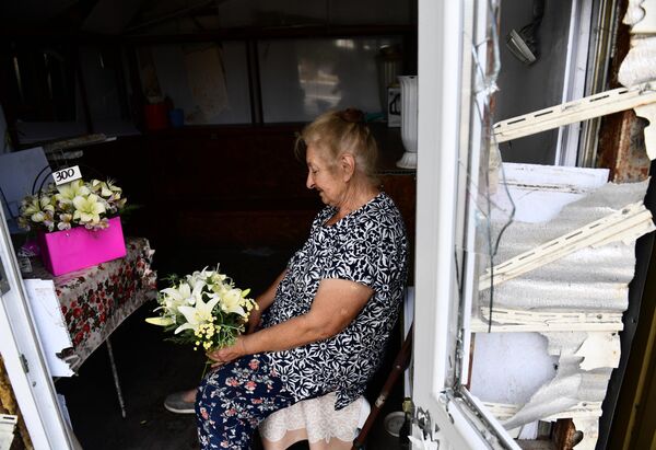 O femeie vinde flori pe o stradă din orașul Volnovaha - Sputnik Moldova