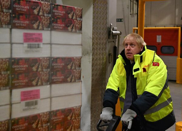Premierul britanic Boris Johnson mută un palet de prăjituri de ciocolată. Imaginea a fost surprinsă pe 8 noiembrie 2019.  - Sputnik Moldova