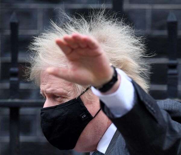 Prim-ministrul Marii Britanii Boris Johnson, purtând o mască pe față părăsește Downing Street-ul din centrul Londrei pentru a participa la sesiunea săptămânală de audiența a premierului britanica în Camera Comunelor, 10 februarie 2021 - Sputnik Moldova-România