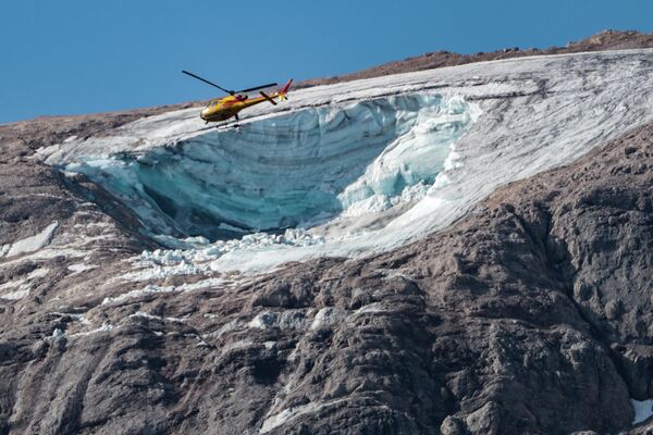 Спасательный вертолет пролетает над ледником, сошедшим на горе Мармолада, Италия. - Sputnik Молдова