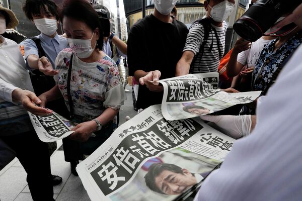 Сотрудник распространяет дополнительные выпуски газеты Yomiuri Shimbun с сообщением покушении на премьер-министра Японии Синдзо Абэ 8 июля 2022 года, Токио. - Sputnik Молдова