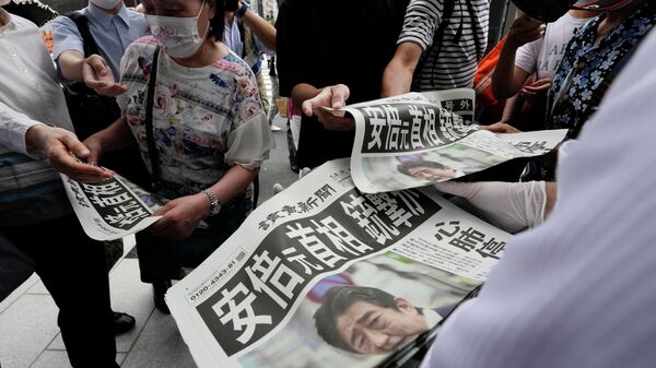 Сотрудник распространяет дополнительные выпуски газеты Yomiuri Shimbun с сообщением покушении на премьер-министра Японии Синдзо Абэ 8 июля 2022 года, Токио - Sputnik Молдова