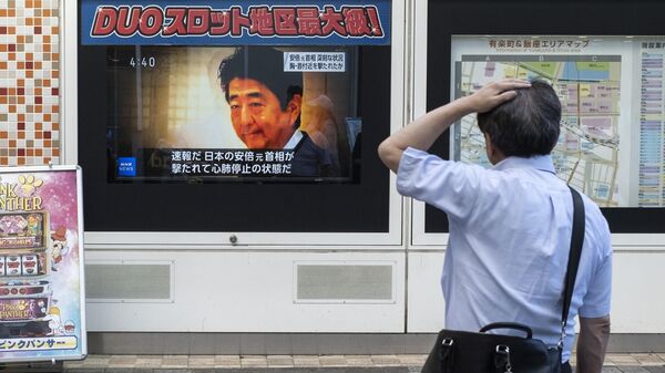 Мужчина смотрит новости о нападении на бывшего премьер-министра Японии Синдзо Абэ ранее в тот же день, на одной из улиц Токио, 8 июля 2022 года - Sputnik Молдова