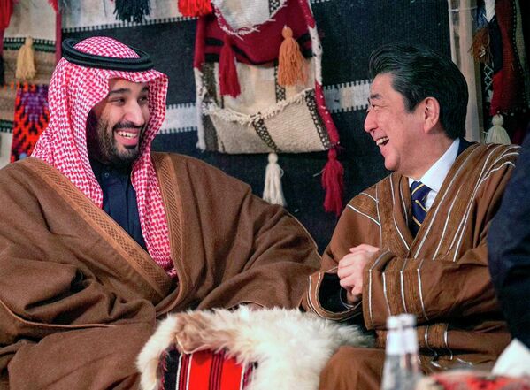 În această fotografie de duminică, 12 ianuarie 2020, publicată de Agenția de presă saudită, SPA, prim-ministrul japonez Shinzo Abe, al doilea la dreapta, purtând un halat tradițional saudit, râde cu prințul moștenitor saudit Mohammed bin Salman în interiorul unui cort din nord-vestul țării, regiunea deșertică Al-Ula, pe care regatul o promovează ca destinație turistică, la nord de Medina, Arabia Saudită. - Sputnik Moldova-România