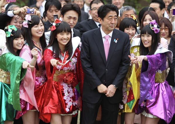Prim-ministrul japonez Shinzo Abe, al treilea la dreapta, pozează cu membrii unității pop pentru fete din Japonia „Momoiro Clover Z” în timpul petrecerii în grădina din parcul de grădină Shinjuku-gyoen din Tokyo, sâmbătă, 20 aprilie 2013. - Sputnik Moldova-România