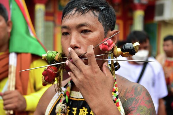 Un bărbat ține în gură mai multe ace, la festivalul celor nouă zei împărați. Evenimentul a avut loc pe 13 iulie în provincia Narathiwat, din sudul Thailandei. - Sputnik Moldova