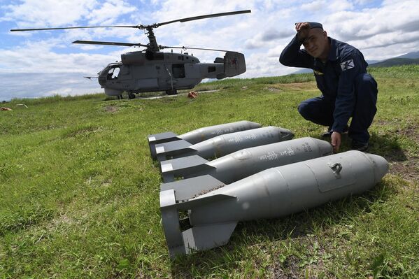 Un specialist în aviație înainte de a atașa bombe de antrenament la un elicopter antisubmarin Ka-27  - Sputnik Moldova-România