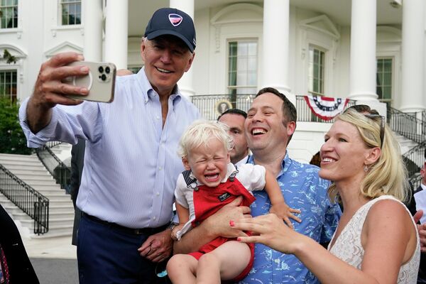 Президент США Джо Байден фотографируется с гостями на пикнике Конгресса Белого дома на Южной лужайке Белого дома во вторник, 12 июля 2022 года, в Вашингтоне. - Sputnik Молдова