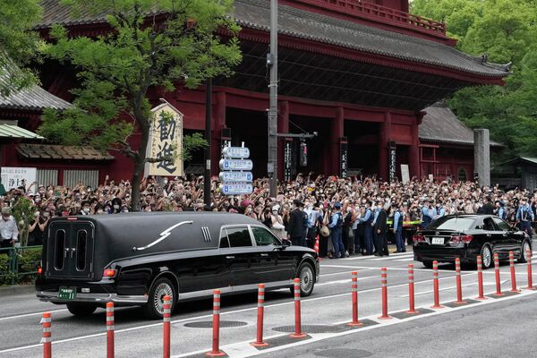 Автомобиль (слева) с телом бывшего премьер-министра Японии Синдзо Абэ выезжает из храма Дзодзёдзи после его похорон в Токио во вторник, 12 июля 2022 года. Абэ был убит в пятницу во время предвыборной кампании в Наре, западная Япония. - Sputnik Молдова