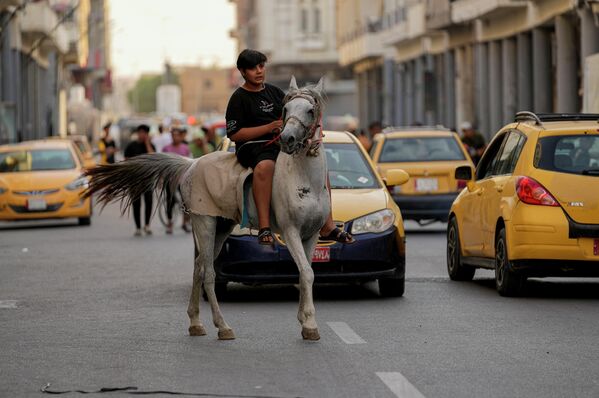 Иракский мальчик едет на лошади во время празднования Ид аль-Адха в центре Багдада, Ирак, понедельник, 11 июля 2022 года.  - Sputnik Молдова