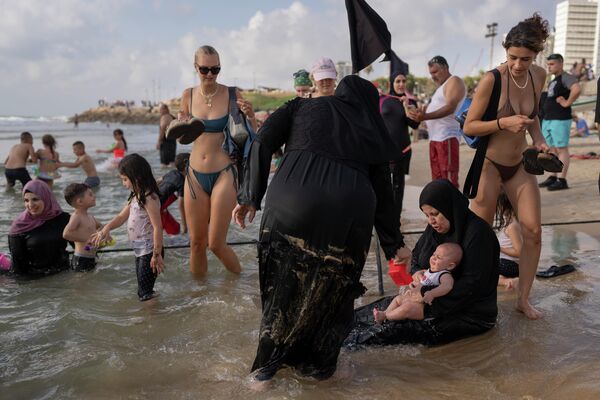 Палестинцы наслаждаются днем на пляже во время фестиваля Курбан-байрам в Тель-Авиве, Израиль, воскресенье, 10 июля 2022 г. Палестинцы посетили Тель-Авив и другие места в Израиле после того, как Израиль предоставил палестинцам с Западного берега разрешения на въезд. - Sputnik Молдова
