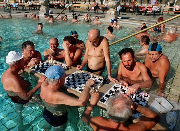 Bucurându-se de soarele cald de la începutul primăverii, localnicii joacă șah în piscina cu apă termală a unei băi în aer liber din Budapesta, marți, 29 februarie 2000. În ultima zi a ultimei luni de iarnă, vremea este uscată și însorită în Ungaria. - Sputnik Moldova-România