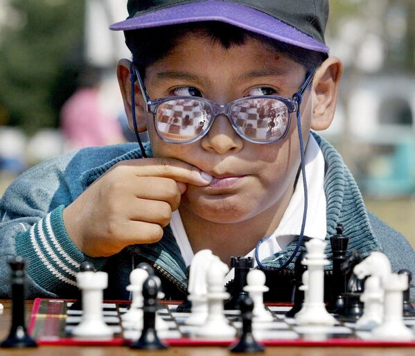 Un școlar argentinian se gândește la următoarea sa mișcare în timpul unui joc de șah pe Plaza de Mayo din Buenos Aires,27 septembrie 2002. - Sputnik Moldova-România