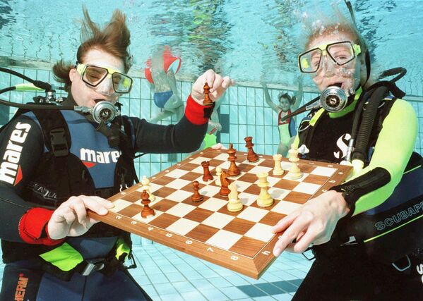 Profesorii de scufundări Michael Rutz, stânga, și Pia Endres de la școala de scufundări „Adrenalin” din satul Lauf de lângă Nuernberg, demonstrează modul lor special de a juca șah: sub apă, într-o piscină,  Miercuri, 27 august 1997. - Sputnik Moldova-România